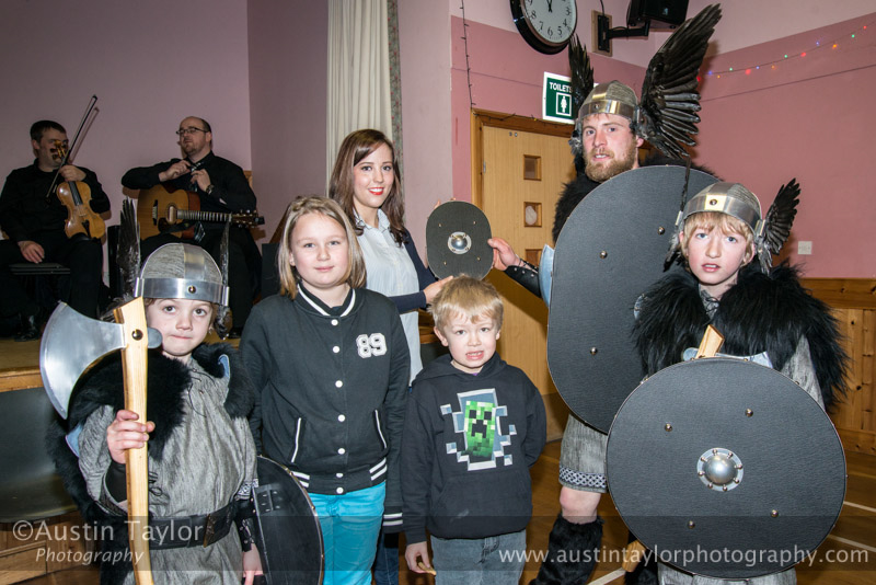 Guizer Jarl Lyle Tulloch presents a shield to Lisa Johnson, Teacher at Bressay Primary School with school pupils Andrew Lowe (P2), Abby Gifford (P5) Dean Gifford (P1) and Brandon Lowe (P7), - Bressay Hall - Bressay Up Helly-Aa 28 February 2014